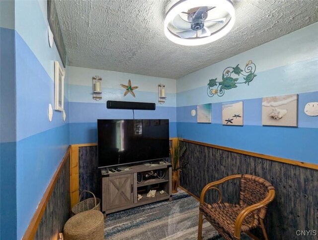 2008 Main St, Vienna, NY 13157 - living room with a textured ceiling, ceiling fan, and wainscoting