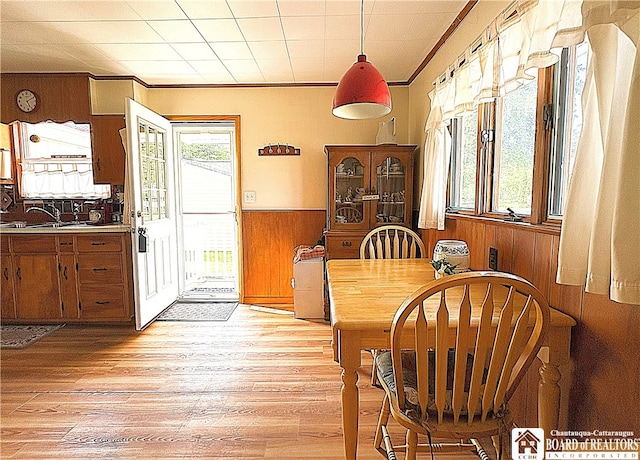2411 Lakeside Dr, Busti, NY 14710 - dining space featuring wood walls, crown molding, light wood-type flooring, and a wainscoted wall