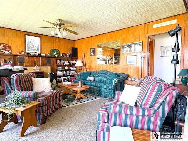 2411 Lakeside Dr, Busti, NY 14710 - living room featuring carpet, wood walls, a ceiling fan, and an ornate ceiling