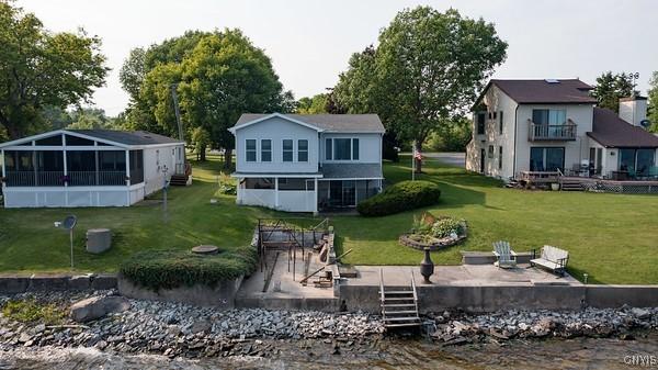 27217 Three Mile Point Rd, Lyme, NY 13622 - rear view of property featuring a sunroom, a lawn, and a deck with water view