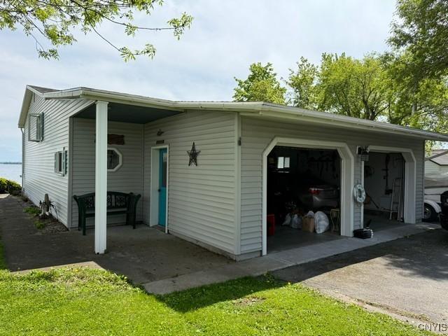 27217 Three Mile Point Rd, Lyme, NY 13622 - view of side of home with asphalt driveway and an attached garage
