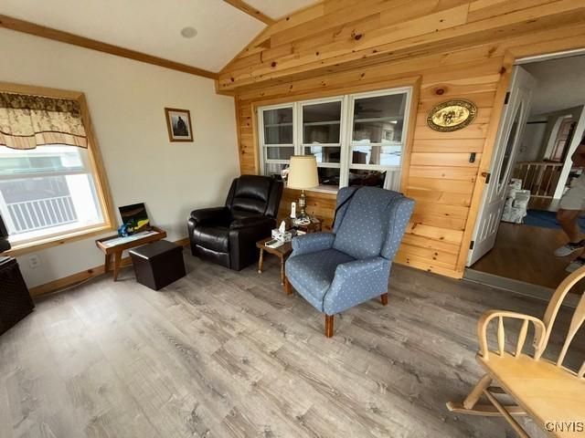 27217 Three Mile Point Rd, Lyme, NY 13622 - sitting room with wooden walls, vaulted ceiling, wood finished floors, and ornamental molding