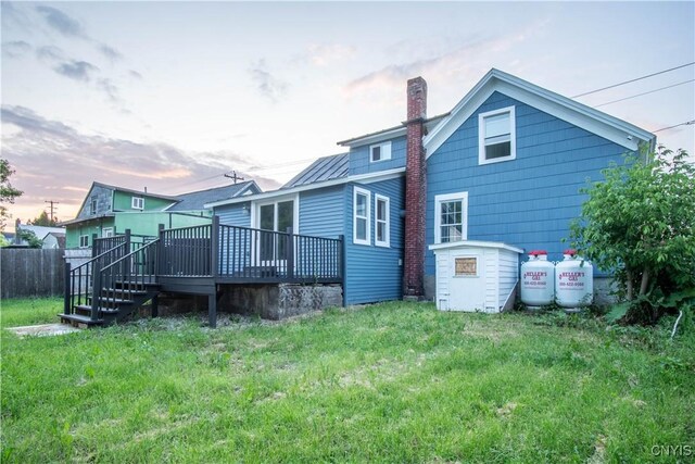 8430 Willow St, Le Ray, NY 13637 - back of property at dusk with a deck and a chimney