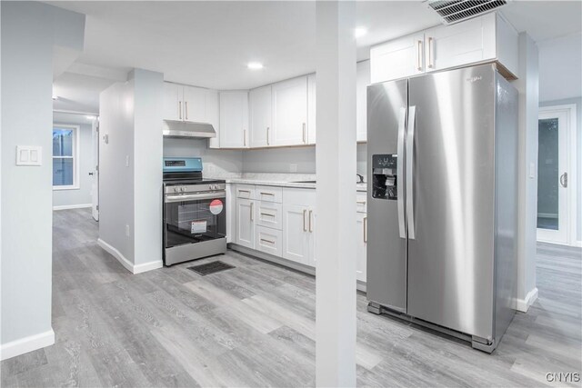 8430 Willow St, Le Ray, NY 13637 - kitchen featuring appliances with stainless steel finishes, under cabinet range hood, white cabinetry, light wood-style floors, and light countertops