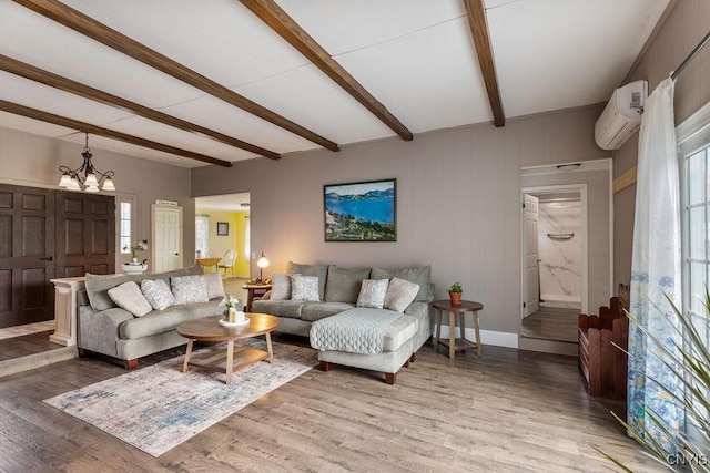 7118 Glass Factory Rd, Trenton, NY 13354 - living room featuring a wall unit AC, beam ceiling, light wood-type flooring, and a chandelier