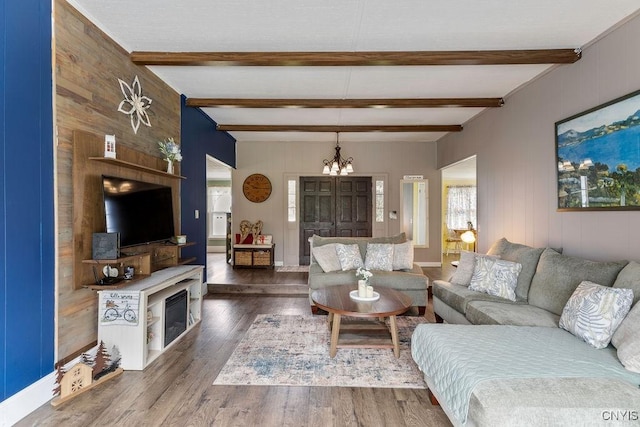 7118 Glass Factory Rd, Trenton, NY 13354 - living area with a chandelier, wood walls, wood finished floors, beamed ceiling, and a fireplace