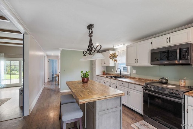 7118 Glass Factory Rd, Trenton, NY 13354 - kitchen with appliances with stainless steel finishes, white cabinets, dark wood-type flooring, a kitchen island, and crown molding