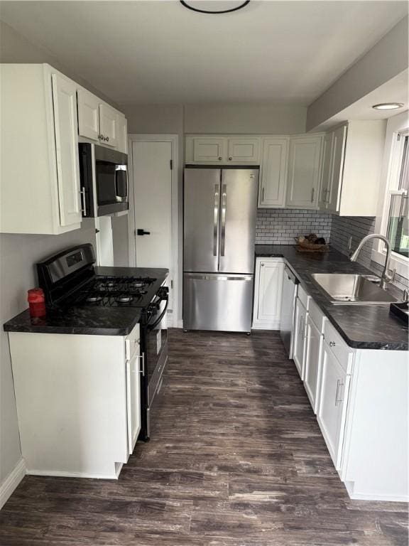 202 Klein St, Rochester, NY 14621 - kitchen featuring stainless steel appliances, dark countertops, dark wood-type flooring, white cabinets, and decorative backsplash