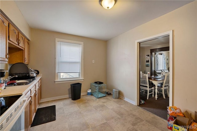 2320 Niagara St, Niagara Falls, NY 14303 - kitchen with white electric stove, light countertops, and brown cabinets