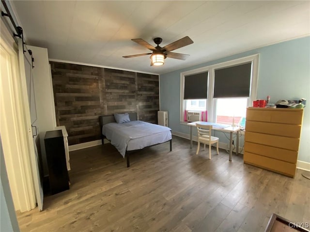 19 Genesee Ct Unit 19, Utica, NY 13502 - bedroom featuring radiator, light wood-type flooring, a barn door, and ceiling fan