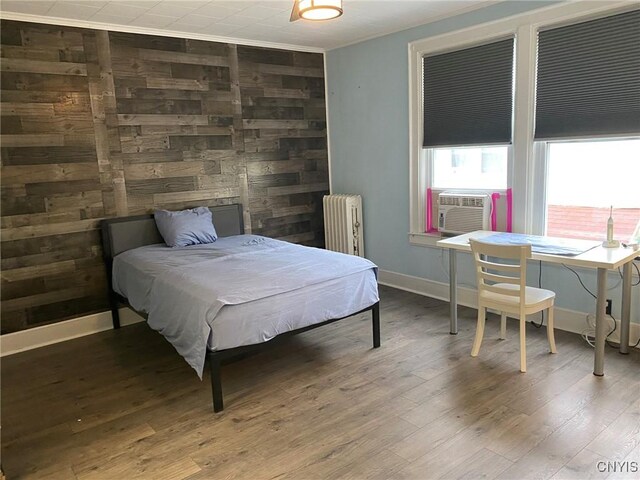 19 Genesee Ct Unit 19, Utica, NY 13502 - bedroom featuring radiator, wood finished floors, cooling unit, and ornamental molding