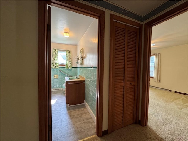 28 Mckune Ave, Foster-Town, PA 16701 - hallway featuring tile walls, light carpet, and wainscoting