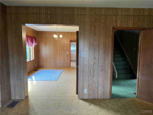 1902 E River Rd, Olean-Town, NY 14760 - carpeted spare room with a chandelier, wood walls, and stairway