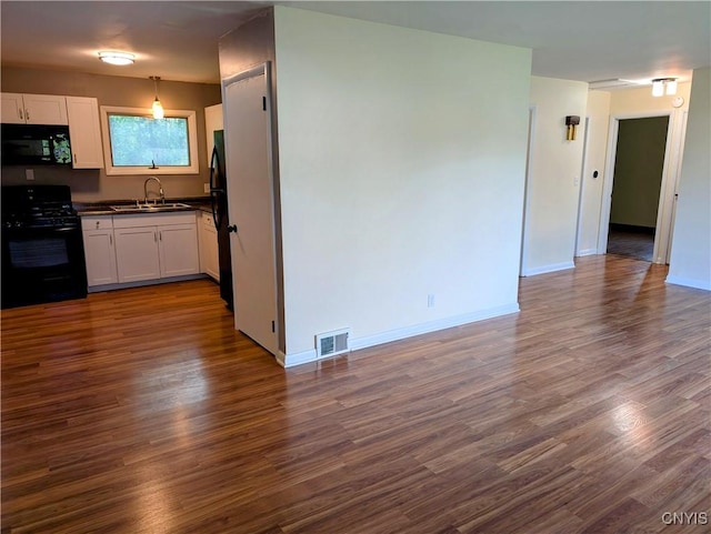6 Cotty Dr, Dewitt, NY 13057 - kitchen with black appliances, dark wood finished floors, dark countertops, white cabinets, and open floor plan