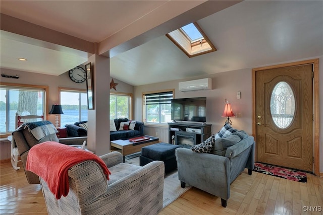 21157 Home St, Alexandria, NY 13607 - living room with light wood-type flooring, a skylight, an AC wall unit, vaulted ceiling, and a fireplace