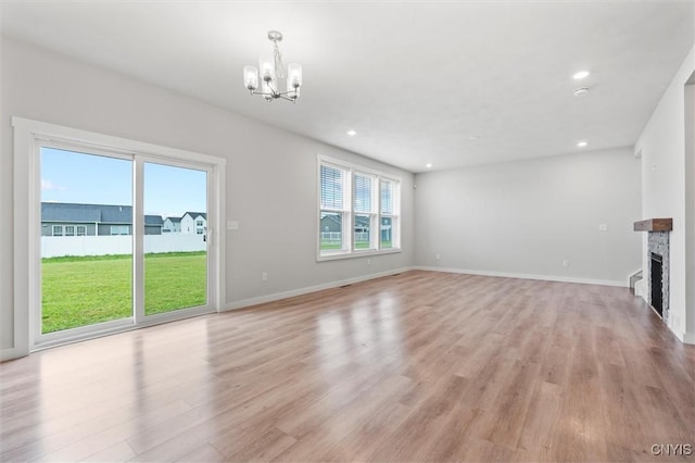 4835 Lepinske Farm Pl, Clay, NY 13041 - unfurnished living room featuring a chandelier, light wood-type flooring, a fireplace, and recessed lighting