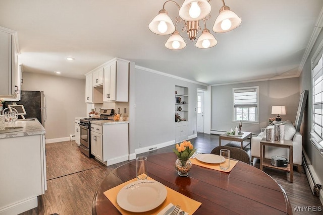 235 Koenig Rd, Tonawanda-Town, NY 14150 - dining room with dark wood finished floors, a baseboard heating unit, a chandelier, crown molding, and built in shelves