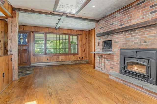 285 Panorama, Penfield, NY 14625 - unfurnished living room featuring a baseboard heating unit, wood-type flooring, a fireplace, wood walls, and beamed ceiling