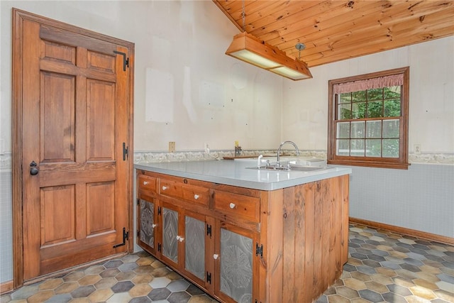 285 Panorama, Penfield, NY 14625 - kitchen featuring wood ceiling, a peninsula, light countertops, brown cabinetry, and a wainscoted wall