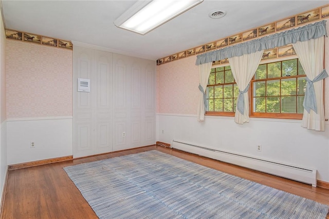 285 Panorama, Penfield, NY 14625 - empty room with baseboard heating, wood finished floors, wallpapered walls, and crown molding