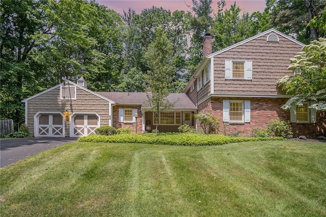285 Panorama, Penfield, NY 14625 - view of front of house featuring brick siding, a front lawn, driveway, an attached garage, and a chimney
