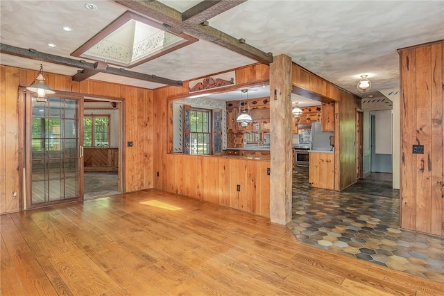 285 Panorama, Penfield, NY 14625 - unfurnished living room featuring wooden walls, hardwood / wood-style flooring, and beam ceiling
