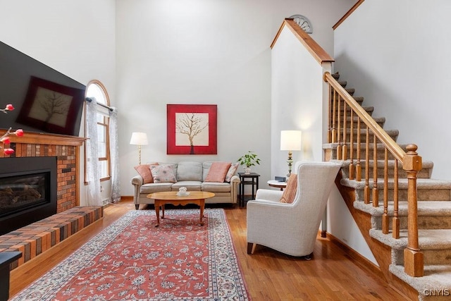 5810 Nobleton Cir, Onondaga, NY 13078 - living room with stairway, wood finished floors, a towering ceiling, and a fireplace