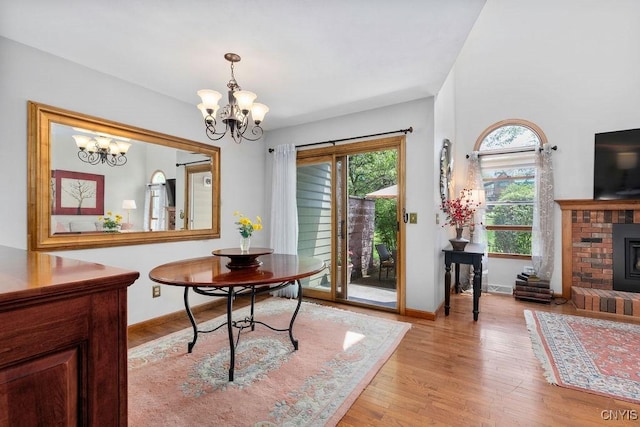 5810 Nobleton Cir, Onondaga, NY 13078 - dining space featuring a chandelier, light wood-style flooring, and a brick fireplace