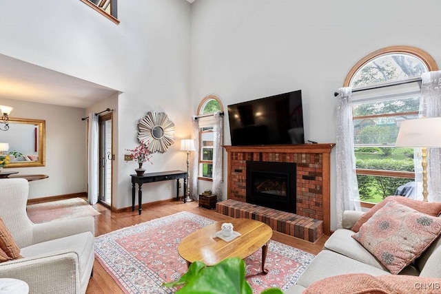 5810 Nobleton Cir, Onondaga, NY 13078 - living room featuring wood finished floors, a brick fireplace, and a high ceiling