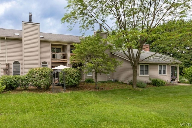 5810 Nobleton Cir, Onondaga, NY 13078 - rear view of house featuring a chimney, a yard, and a balcony