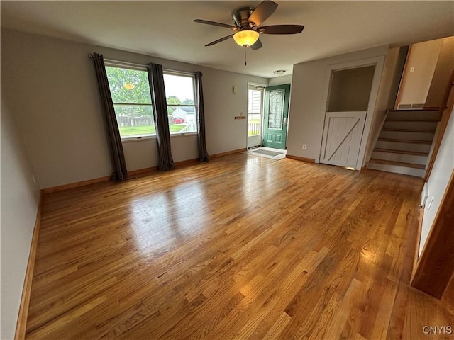 8071 Evesborough Dr, Clay, NY 13041 - unfurnished room featuring light wood-style floors, stairs, and ceiling fan