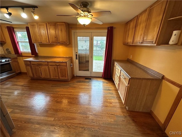 8071 Evesborough Dr, Clay, NY 13041 - kitchen featuring stainless steel gas range, dark wood-style floors, ceiling fan, dark countertops, and rail lighting