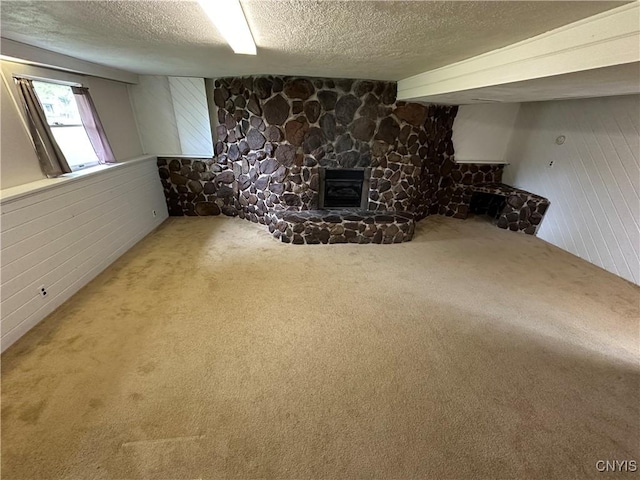 8071 Evesborough Dr, Clay, NY 13041 - basement featuring a textured ceiling, a fireplace, carpet, and wood walls