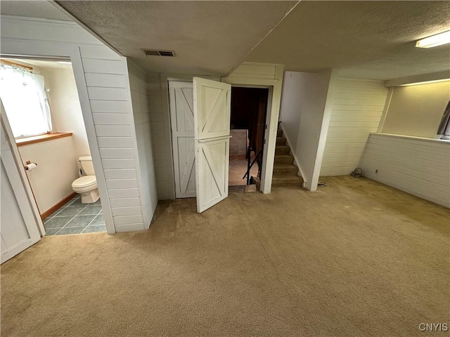 8071 Evesborough Dr, Clay, NY 13041 - unfurnished bedroom with carpet, a textured ceiling, wood walls, and ensuite bathroom