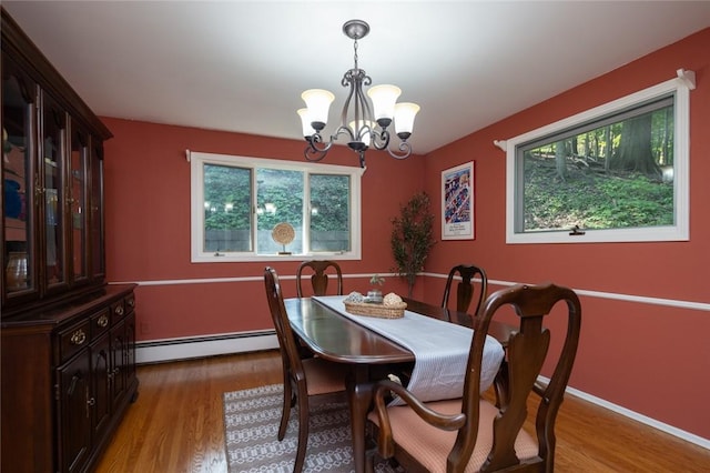 151 Chapel Hill Dr, Irondequoit, NY 14617 - dining area featuring a baseboard heating unit, a chandelier, healthy amount of natural light, and light wood-style floors