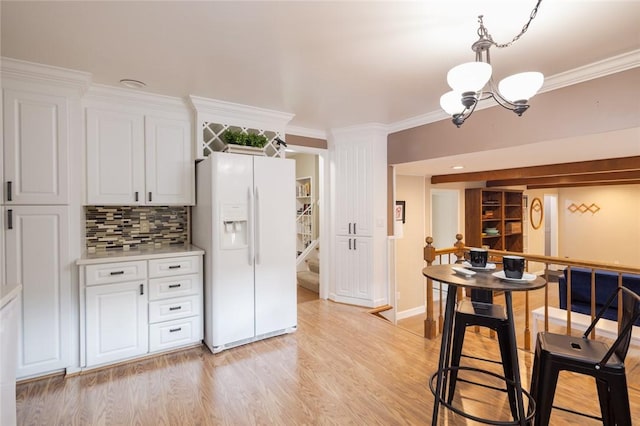 151 Chapel Hill Dr, Irondequoit, NY 14617 - kitchen featuring white fridge with ice dispenser, a chandelier, ornamental molding, white cabinets, and light countertops