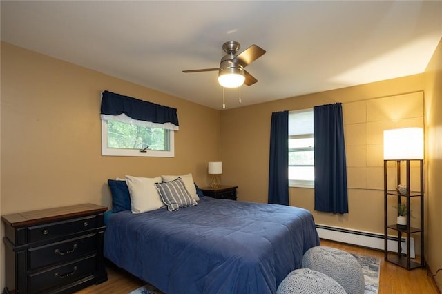 151 Chapel Hill Dr, Irondequoit, NY 14617 - bedroom featuring a baseboard heating unit, multiple windows, wood finished floors, and a ceiling fan