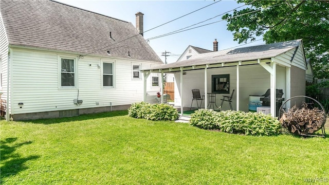 610 Huth Rd, Cheektowaga, NY 14225 - back of house with a chimney, roof with shingles, and a lawn