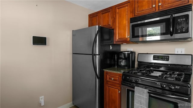 610 Huth Rd, Cheektowaga, NY 14225 - kitchen featuring appliances with stainless steel finishes, dark stone countertops, and brown cabinetry