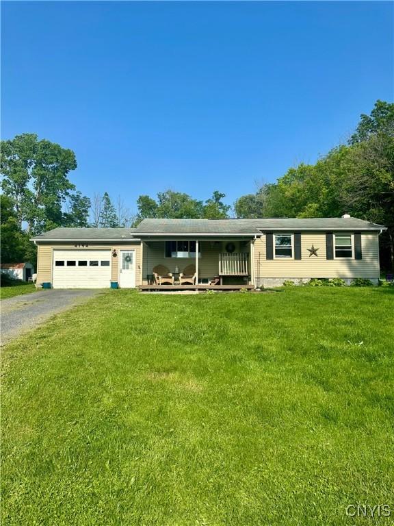 4154 State Route 90, Springport, NY 13160 - single story home with asphalt driveway, a garage, a front yard, and covered porch