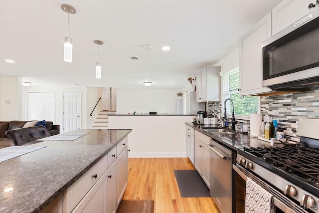 13 Berrywood Rd, Clay, NY 13090 - kitchen featuring stainless steel appliances, backsplash, light wood-style flooring, hanging light fixtures, and white cabinets