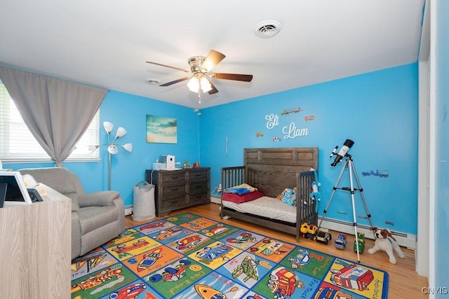 13 Berrywood Rd, Clay, NY 13090 - bedroom with wood finished floors, a baseboard radiator, and ceiling fan
