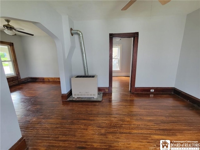 116 Park St, Jamestown, NY 14701 - unfurnished living room with ceiling fan, heating unit, hardwood / wood-style floors, and arched walkways