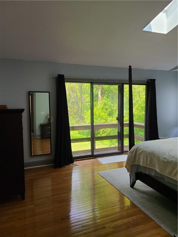 1324 New Seabury Ln, Victor, NY 14564 - bedroom featuring multiple windows, wood finished floors, and a skylight