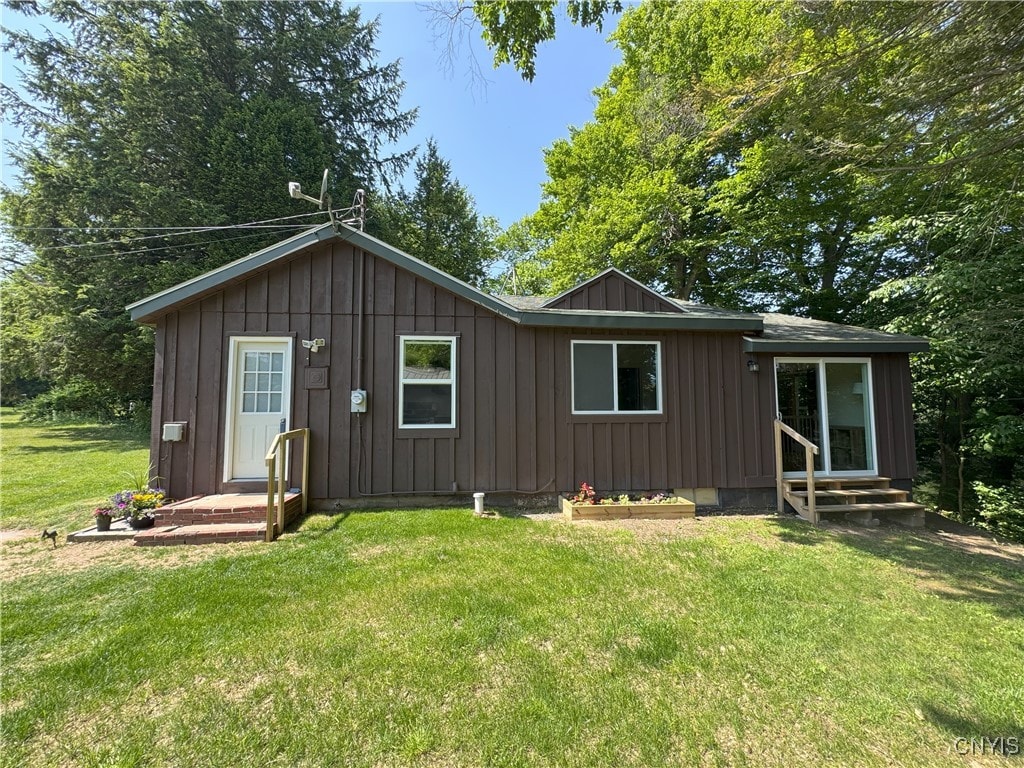 42 Leo J Bidwell Ave, Palermo, NY 13135 - rear view of property with board and batten siding, entry steps, and a yard