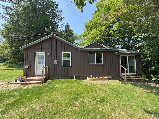 42 Leo J Bidwell Ave, Palermo, NY 13135 - rear view of property with board and batten siding, entry steps, and a yard