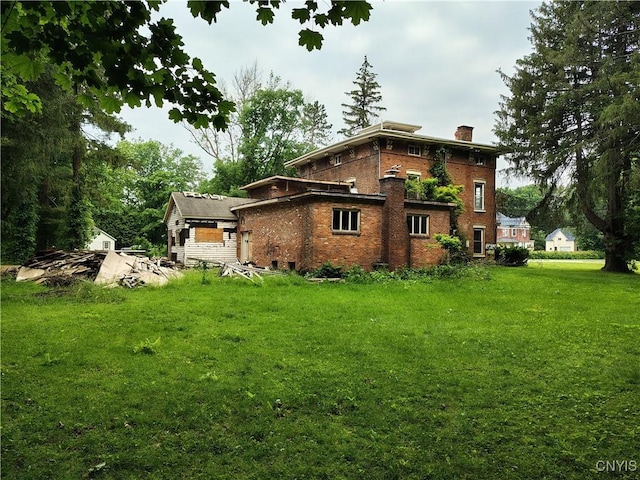 756 Herkimer Rd, Utica, NY 13502 - view of side of property with a chimney, brick siding, and a yard