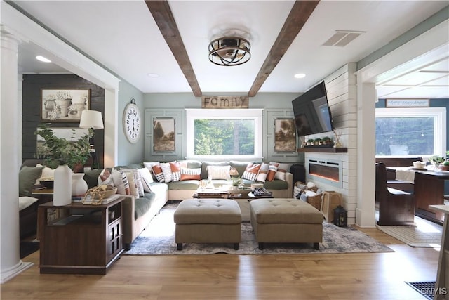 31768 Wilton Rd, Rutland, NY 13619 - living room with beamed ceiling, plenty of natural light, wood finished floors, and a large fireplace