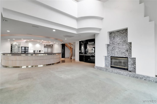 40 Waterfront Cir, Buffalo, NY 14202 - unfurnished living room with light colored carpet, recessed lighting, a high ceiling, and a premium fireplace