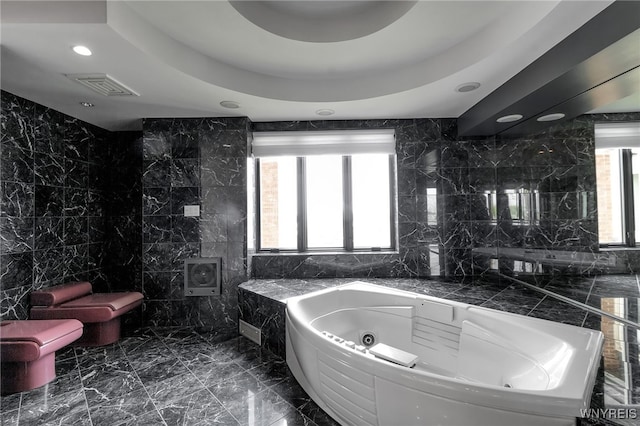 40 Waterfront Cir, Buffalo, NY 14202 - bathroom featuring tile walls, a jetted tub, marble tiled floors, and recessed lighting